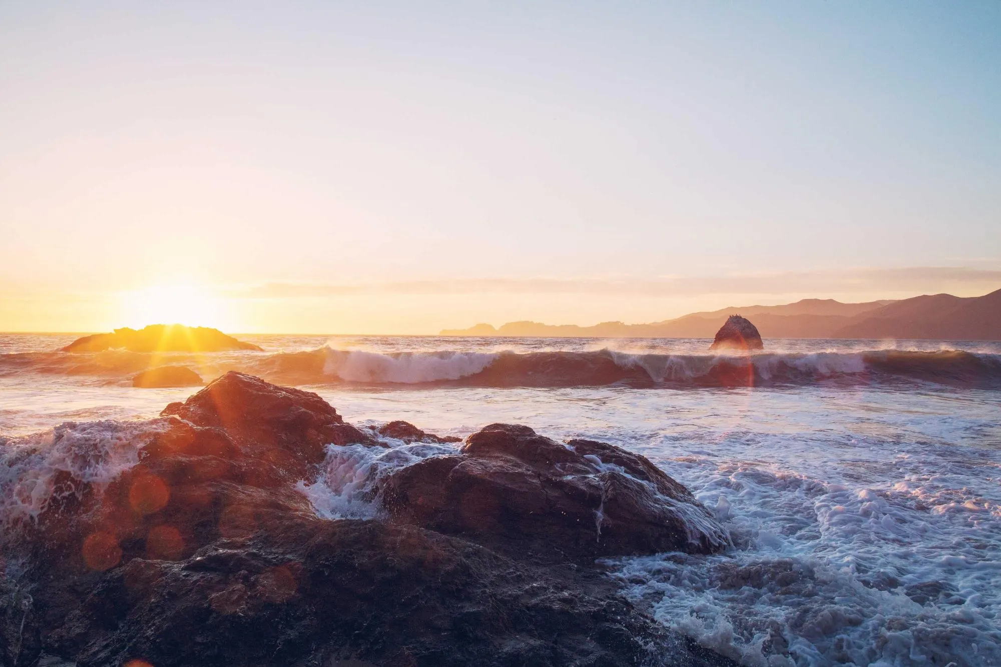 A random stock photograph, waves breaking on dark rocks at sunset, standing in for this demo project's image.